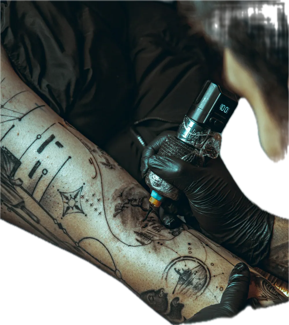 Tattoo artist working on a client's leg