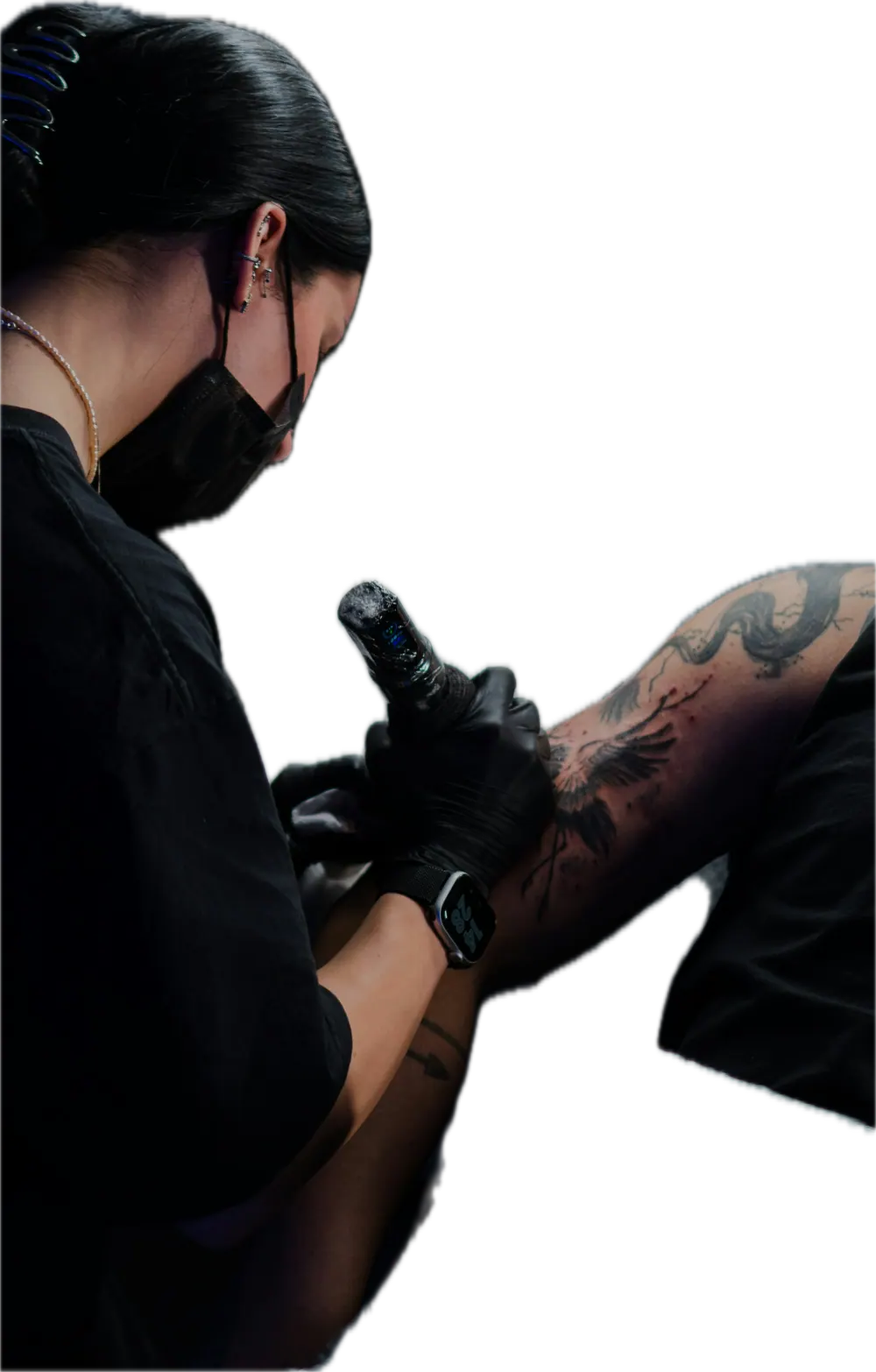 Tattoo artist working on a client's arm