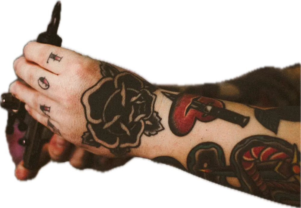 Tattooed hand holding a tattoo machine