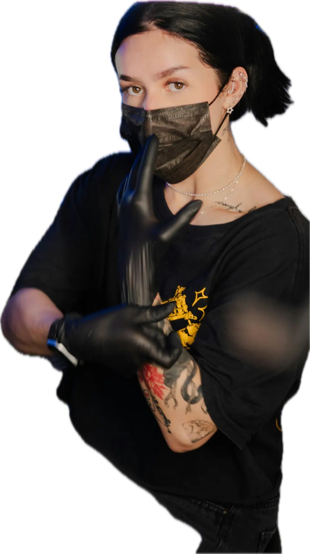 Tattoo artist in a black mask making a quiet gesture