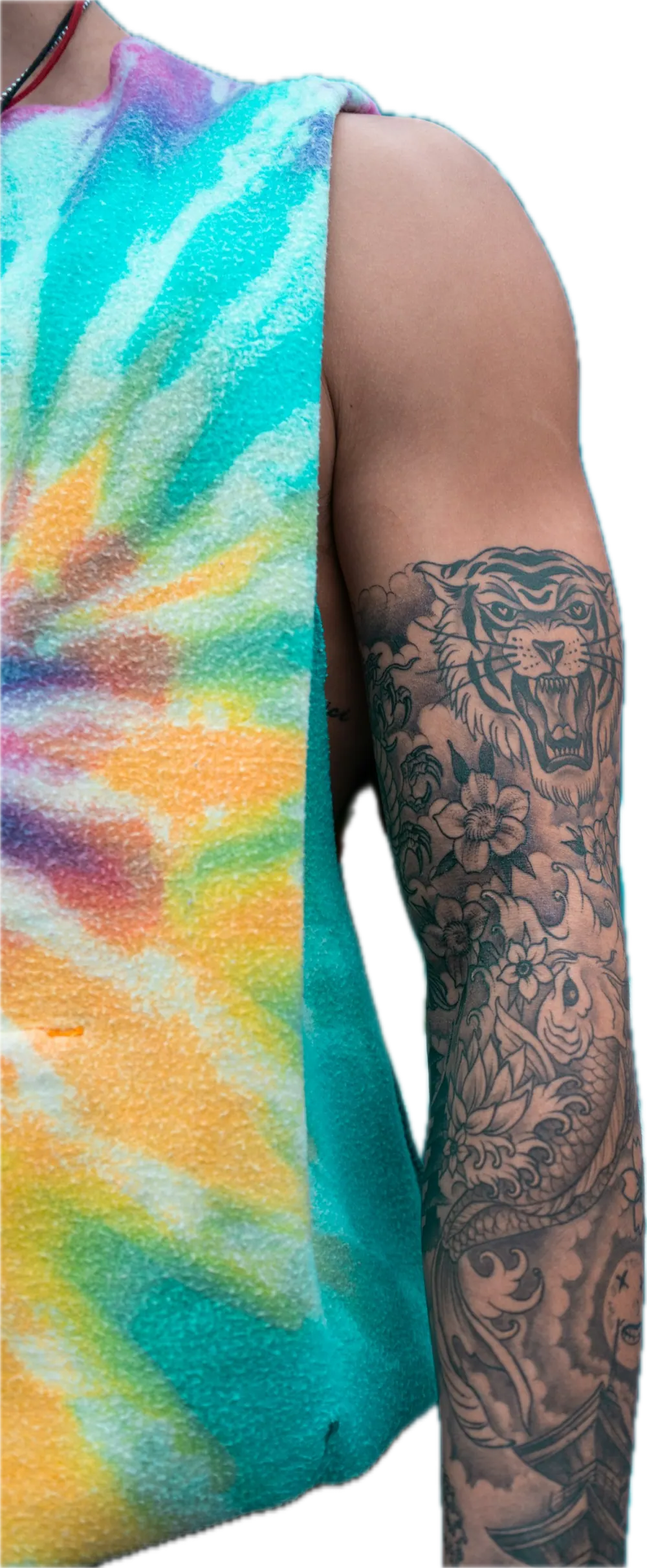 Tattooed arm beside a tie dye vest