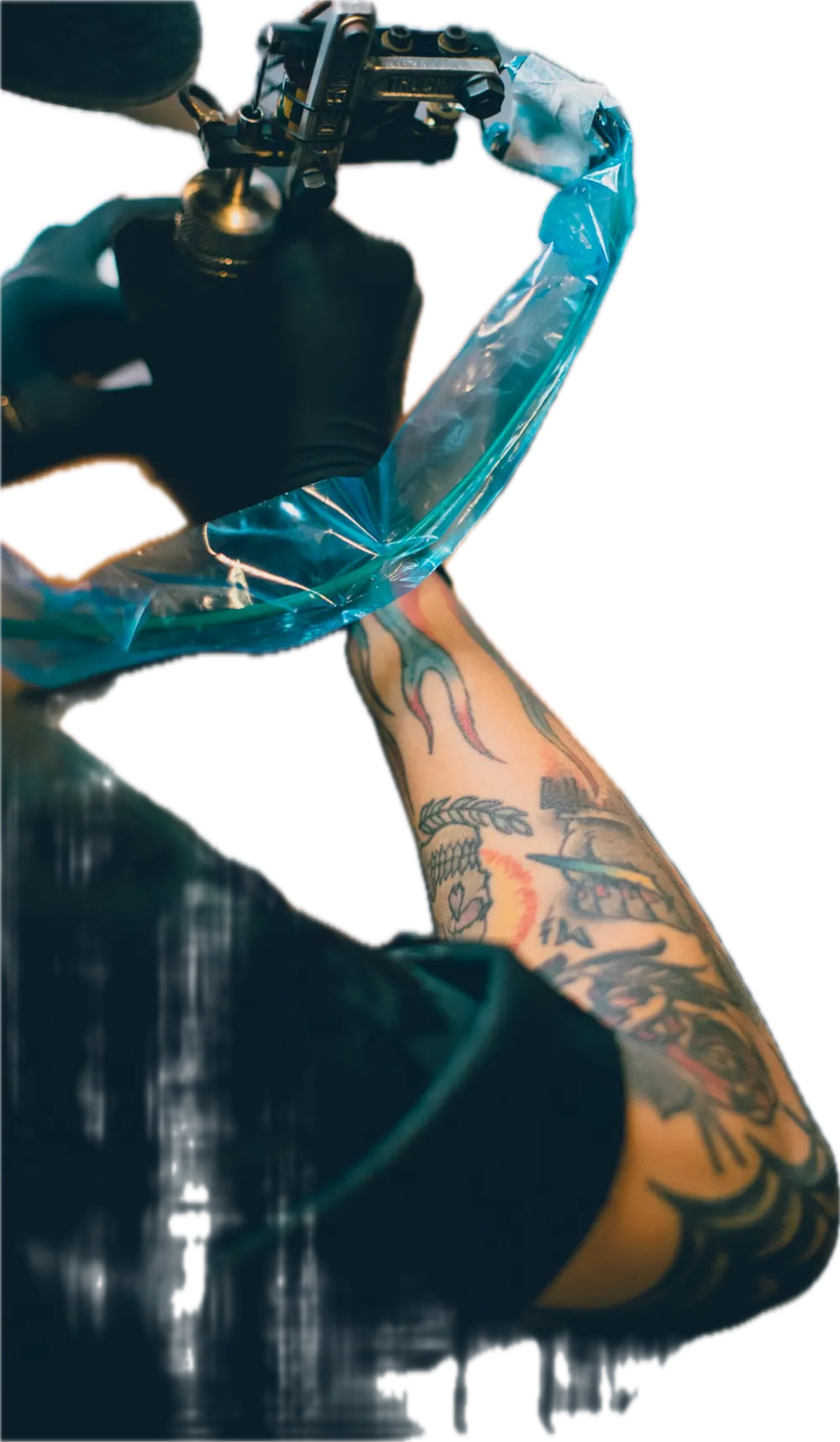 Arm wrapped for tattooing beside a machine
